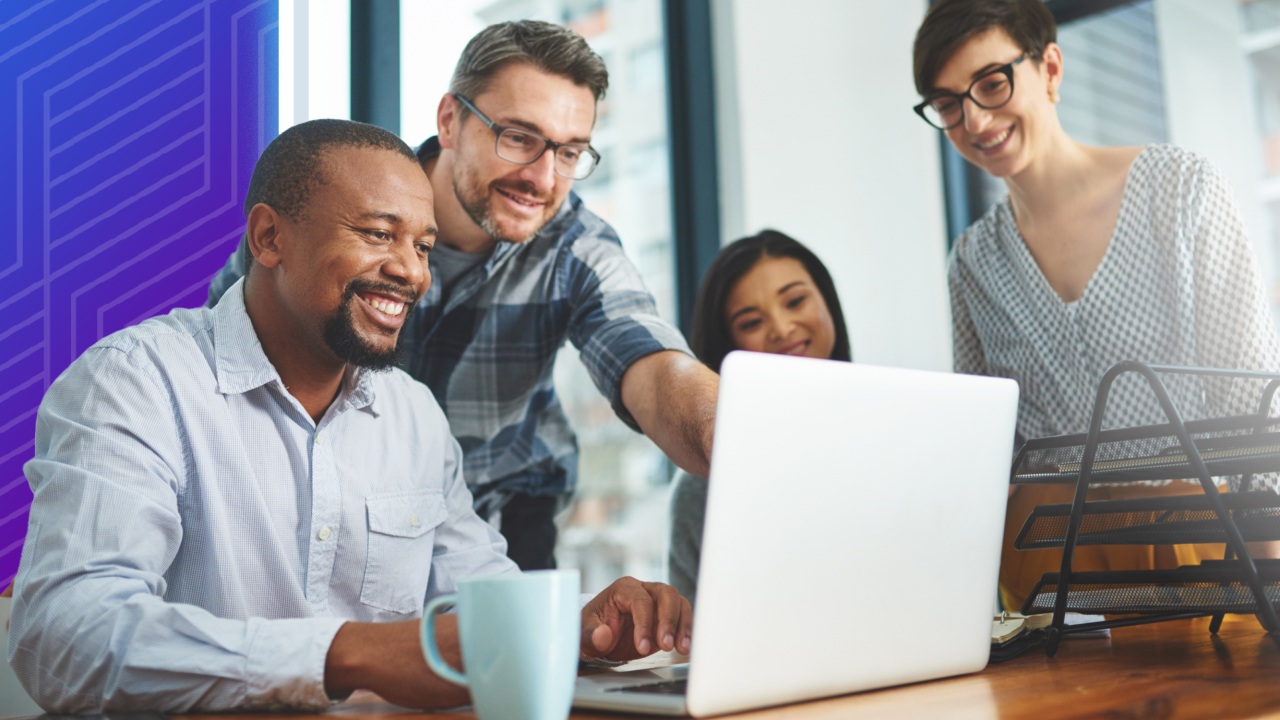 Colleagues gathered around a computer 