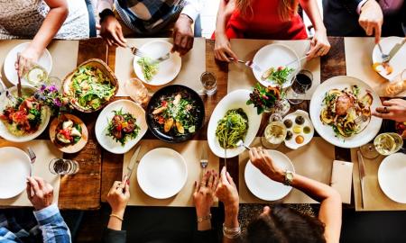 People at a dinner table, focus is on plates of food