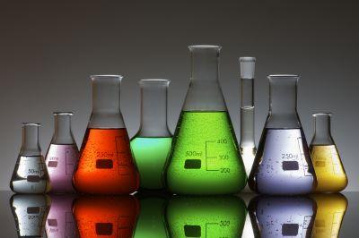 Chemical beakers containing different color liquids.