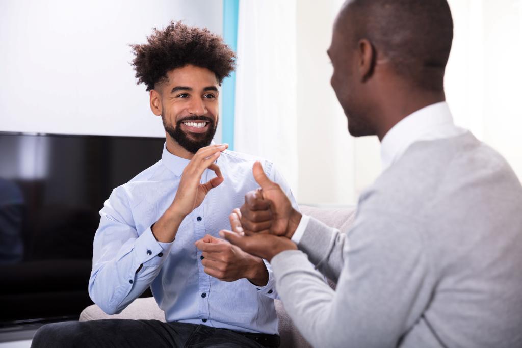 2 handsome black men signing in business casual.